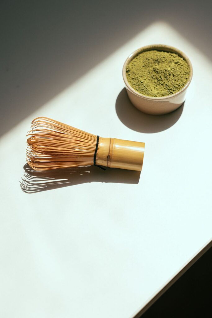 Chasen (Bambus-Quirl) neben Matcha-Pulverschale im Sonnenlicht – traditionelles Handwerkszeug